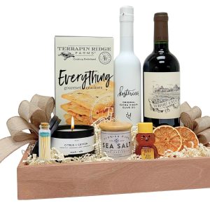Celebrate a new home with a housewarming gift basket featuring wine, olive oil, gourmet crackers, honey, sea salt and a scented candle.