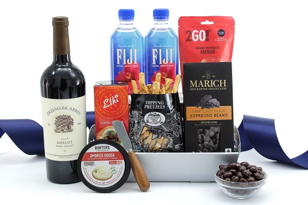 Gourmet gift basket with a bottle of wine, ideal for a hotel room.