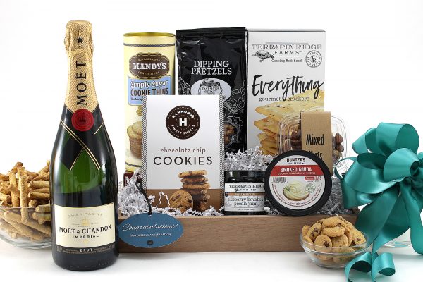 A gift basket of congratulations with yummy snacks and a bottle of wine - we suggest bubbles for a traditional congratulations!