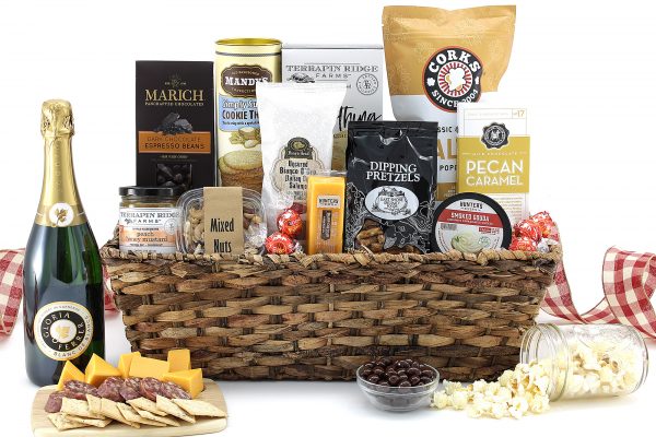 Large gift basket overflowing with a variety of gourmet treats and a bottle of wine.