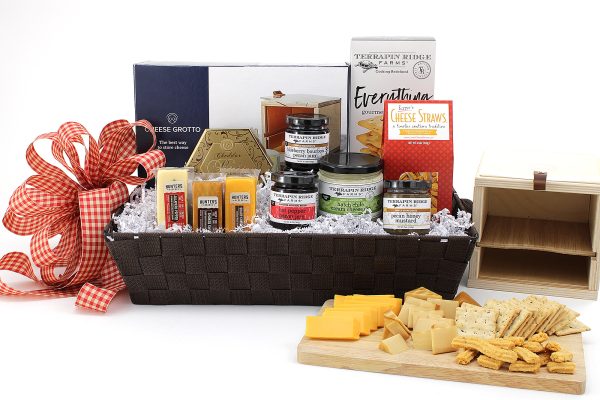 A gift basket with a large variety of cheesy snacks plus a cheese grotto - a unique way to storage cheese. A great addition to any kitchen!