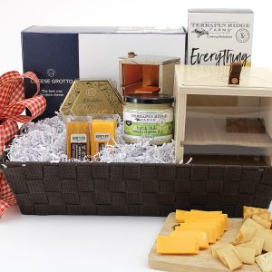 A gift basket with a variety of cheesy snacks plus a cheese grotto - a unique way to storage cheese. A great addition to any kitchen!