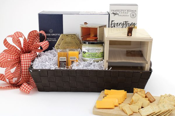 A gift basket with a variety of cheesy snacks plus a cheese grotto - a unique way to storage cheese. A great addition to any kitchen!