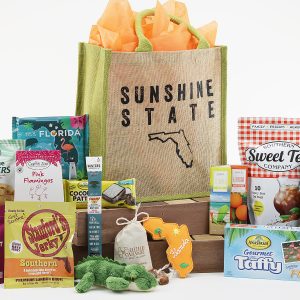 A tote bag with the famous "Sunshine State" nickname and outline of our famous shape. Tote bag is filled with Florida-inspired treats!