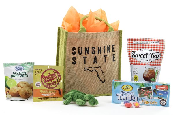 A tote bag with the famous "Sunshine State" nickname and outline of our famous shape. Tote bag is filled with Florida-inspired treats!