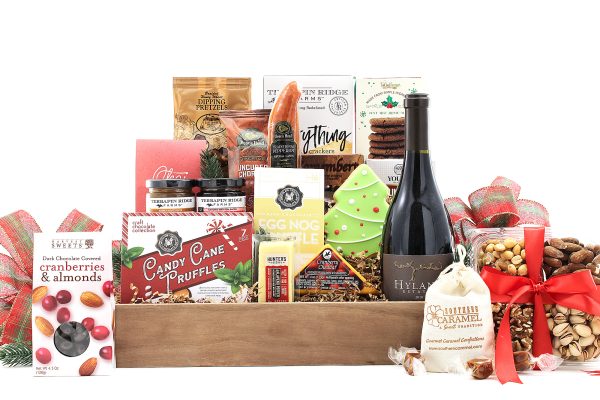 A large gift basket full of gourmet goodies, a bottle of wine, and a touch of holiday flair!