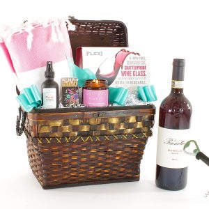 A gift basket full of daily luxuries, including a bottle of wine.